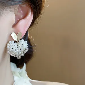 Detailed close-up of a French style heart earring with pearls and 14k gold plating