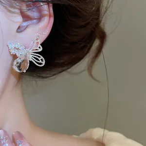 Détail macro d'une boucle d'oreille papillon élégante avec zircon et cristal goutte d'eau