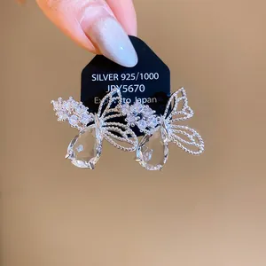 Détail des boucles d'oreilles papillon en zircon avec gouttes d'eau sur tiges en argent.