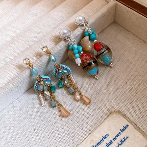 Detailed view of vintage-style earrings featuring elegant pearls and colorful artistic glass beads
