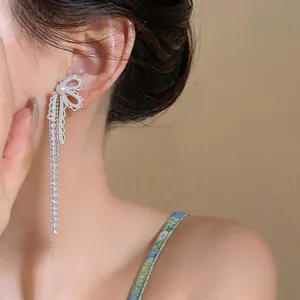 Detailed shot of sparkling zircon bowknot earring with elegant long pearl tassel