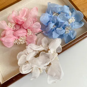 Detail showing elegant chiffon flower scrunchies with white pearl decorations