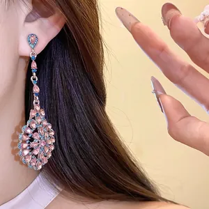 Orecchini pendenti vintage in argento con strass rosa e blu su una modella femminile.