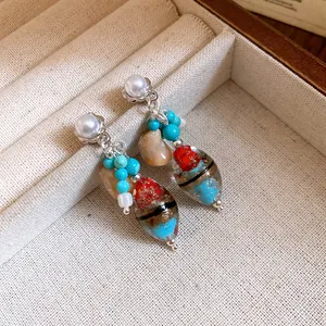 Detailed view of vintage earrings featuring pearls, turquoise stones and lampwork glass beads