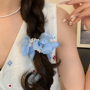 Detail showing blue chiffon flower hair scrunchie with pearls on a braided hairstyle.