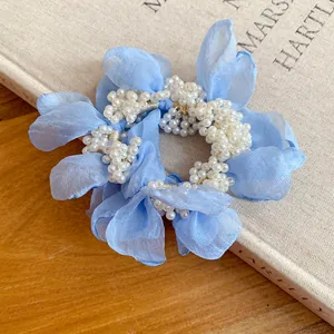 Close-up of a blue chiffon flower hair tie with white pearl center for elegant hair styling