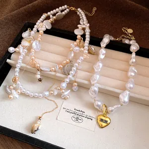 Close-up of vintage pearl and shell necklaces displayed in a beige jewelry box