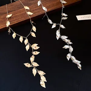 Detailed macro view showing the pleated leaf texture on gold and silver tassel necklaces.