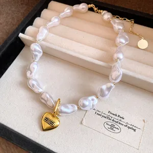 Elegant baroque pearl necklace with gold heart pendant in a jewelry display box