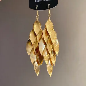 Eleganti orecchini a pendente con foglie dorate a strati e texture metallica spazzolata