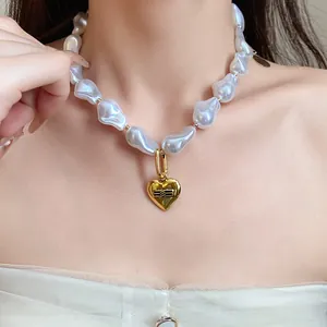 Detailed view of a baroque pearl necklace featuring a vintage golden heart pendant.
