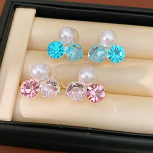 Macro detail of elegant crystal pearl ear clips in blue and pink for non-pierced ears.