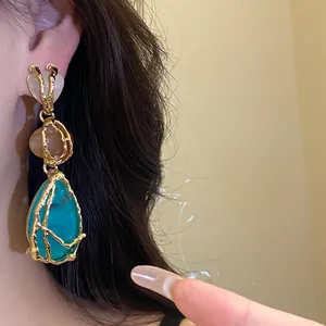 Detail of vintage resin teardrop earrings with gold-toned textured metal frame