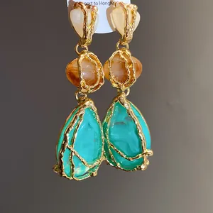 Detailed view of vintage resin teardrop earrings with textured gold frame and heart detail