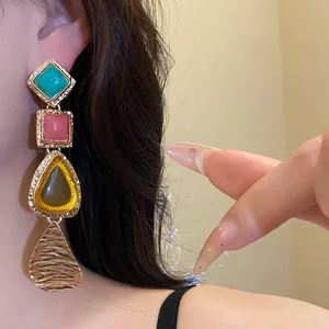 Close-up of colorful resin vintage drop earrings featuring a unique tiered design style.