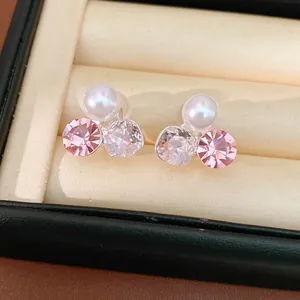 Detailed view of elegant non-pierced pearl ear clips with pink and clear crystals in box