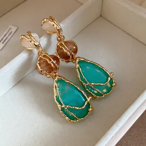 Detailed macro view of vintage teardrop resin earrings featuring textured gold frames