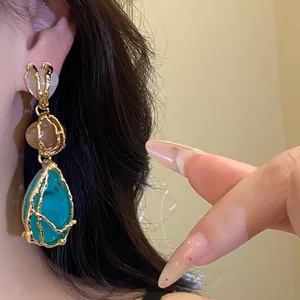 Detailed view of vintage resin teardrop dangle earrings with gold textured frame