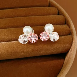 Close-up detail of elegant clip-on earrings with pink and clear crystals and a pearl
