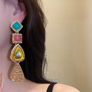 Macro shot of vintage style resin drop earrings featuring colorful geometric pendants