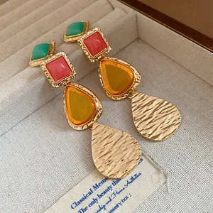Detailed macro view of vintage resin teardrop earrings with colorful stone accents