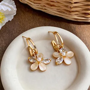18k gold plated flower stud earrings with elegant zircons and pearls on white tray