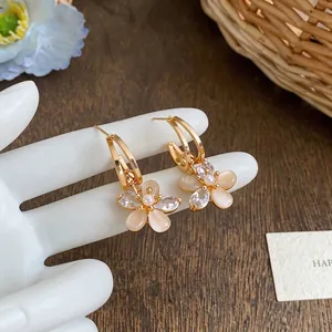 Elegant 18k gold-plated floral stud earrings with sparkling zircon and opal-like petals.
