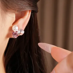 Detailed macro view of elegant pearl and pink crystal clip-on earring on ear model