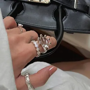 Close-up of 18k gold plated resin open rings styled on fingers with a luxury background.