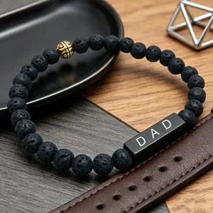 Detailed view of black lava rock bead bracelet with DAD engraved metal accent bead