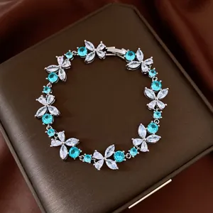 Detailed view of elegant flower bracelet with blue and white cubic zirconia stones.