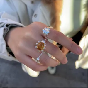Detail view of 18k gold plated open ring with amber resin stone on model's hand