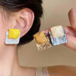 Close-up detail of unique wrinkled resin square stud earrings in stylish multi-color set