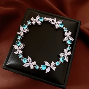 Close-up of elegant flower bracelet with blue and white zircons on a black box