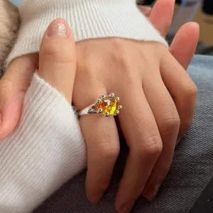 Detail shot of round yellow resin open ring on finger for a stylish fashion look.