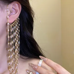 Close-up of elegant gold tassel ear cuff with sparkling marquise zircons on model