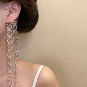 Elegant silver zircon tassel ear cuff shown on model's ear in close-up detail.