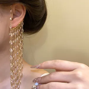 Close-up detail of a sparkling gold zircon tassel ear cuff worn on an elegant model