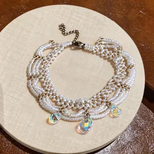 Detail showing iridescent teardrop crystals on white beaded lace bracelet