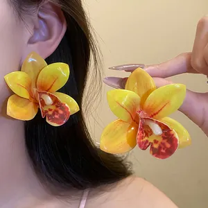 Grandi orecchini a lobo a forma di orchidea gialla in resina indossati per le vacanze