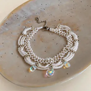 Close-up of handmade white seed bead bracelet with iridescent glass teardrops