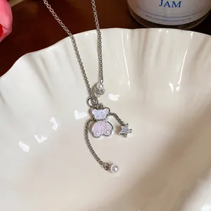 Elegantes Detail einer Silberkette mit einem Glasbären-Anhänger und einem Zirkonia-Stern