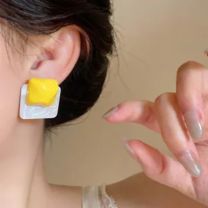 Detail of yellow wrinkled resin square earrings with unique marble pattern finish