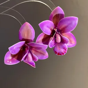 Macro di orecchini a forma di orchidea in resina viola fatti a mano con perni d'argento