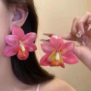 Dettaglio degli orecchini a fiore di orchidea in resina rosa con ago in argento