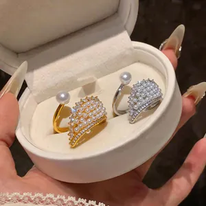 Detail showing elegant French style pearl wing open rings in gold and silver finish