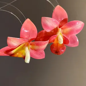Elegante dettaglio ravvicinato di orecchini a orchidea rosa in resina lucida