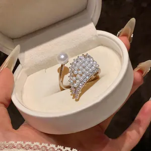 Macro view of an elegant wing-shaped open ring featuring white pearls and zircons