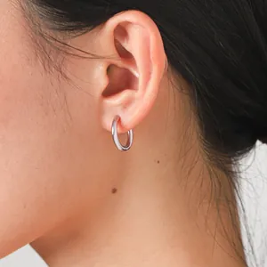 Silver titanium steel huggie hoop earring worn on ear for minimalist jewelry detail