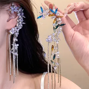Detailed view of an elegant zircon flower ear cuff with long crystal tassels on model